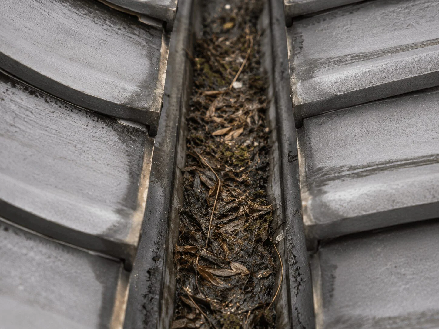 山間部の住宅で落ち葉による谷樋詰まりを清掃・板金補修し雨漏りを解消した事例