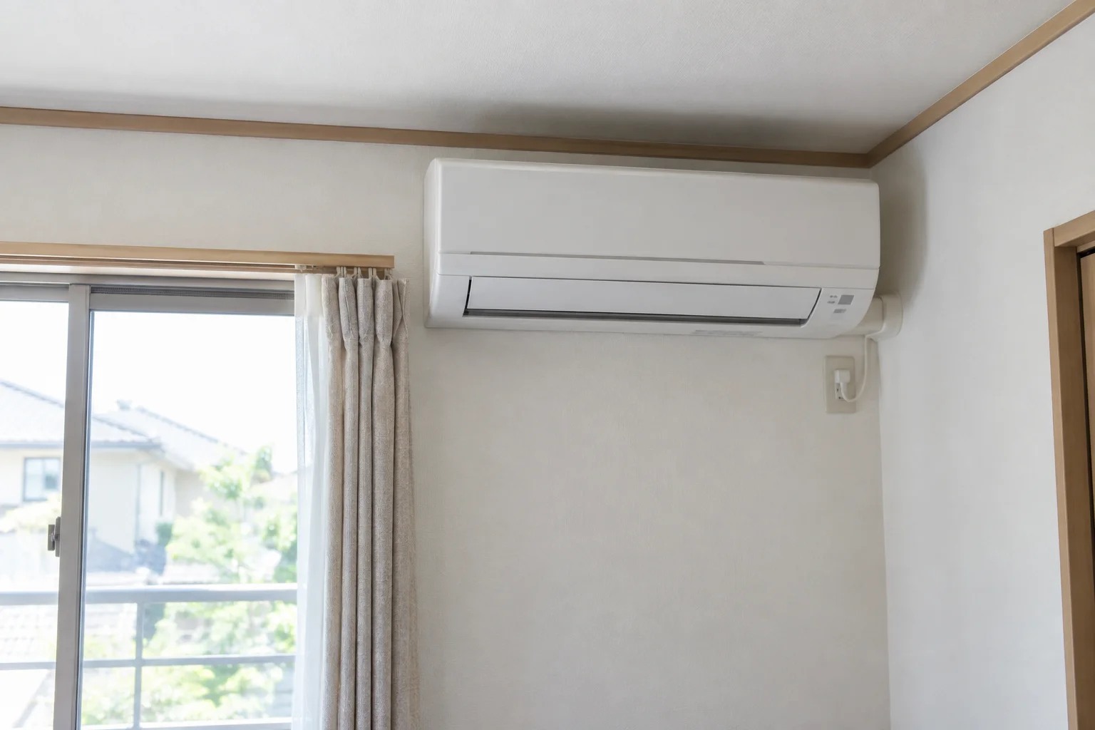窓のある住宅の室内に設置された壁掛けエアコン