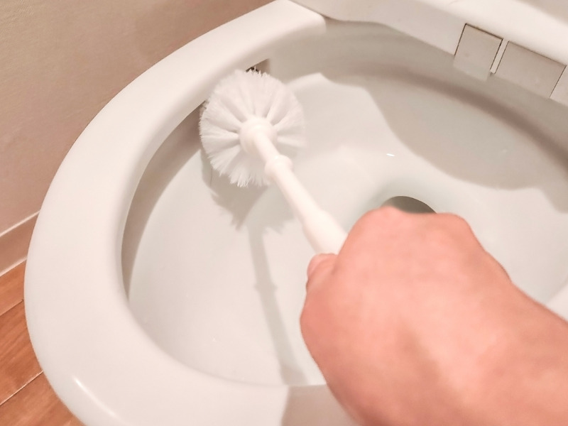 ブラシで便器を掃除している様子