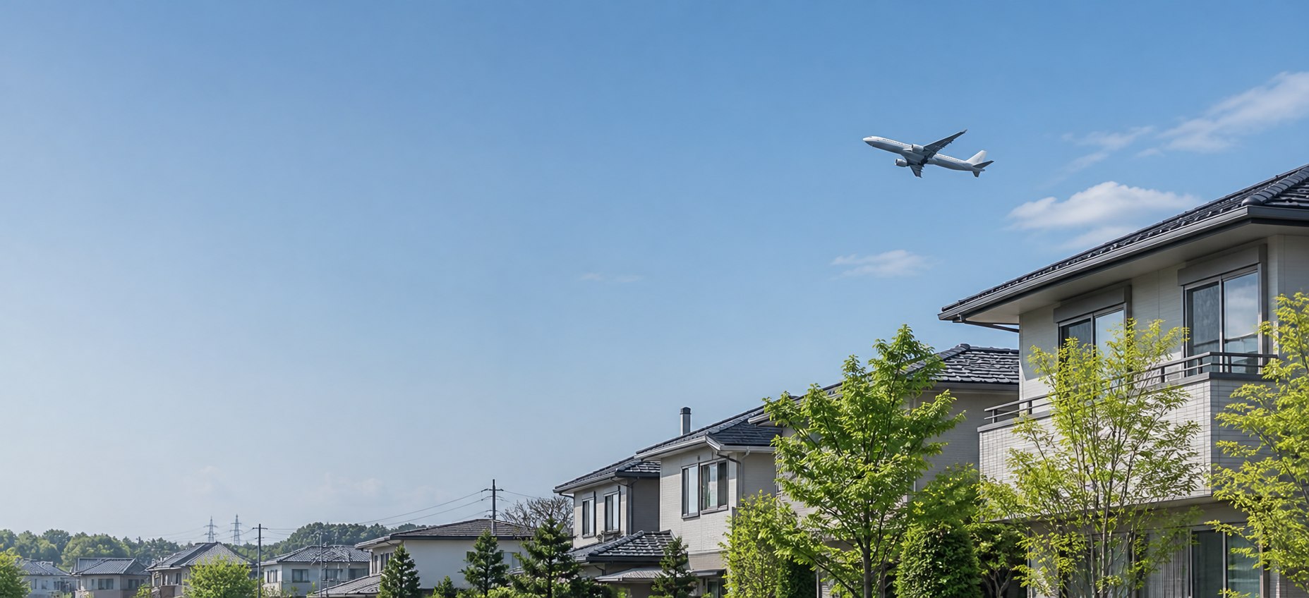 成田空港周辺の住宅街上空を飛ぶ旅客機のイメージ